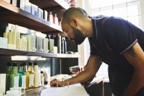 Homme propriétaire de salon de coiffure faire de la paperasse — Photo de stock