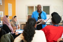 Female teacher and multi-ethnic students in classroom — Stock Photo