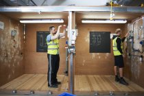 Estudiantes masculinos de electricista practicando en taller - foto de stock