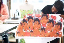 Artista feminina segurando impressão de tela no estúdio de arte — Fotografia de Stock