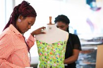 Female fashion designers using dressmakers model — Stock Photo