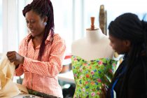 Female fashion designers at dressmakers model in studio — Stock Photo