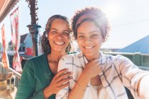 Point of view of smiling, happy mother and daughter on sunny balcony — Stock Photo