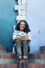 Ritratto di donna sorridente e sicura di sé seduta su gradini di mattoni — Foto stock