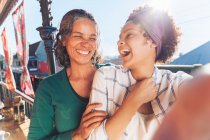 Selfie point of view of laughing, happy mother and daughter on sunny balcony — Stock Photo