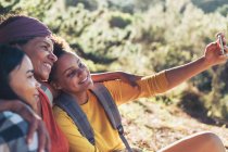 Happy mother and daughters taking selfie with camera phone — Stock Photo