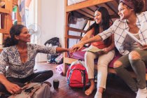 Mother and daughters backpackers joining hands, staying at youth hostel — Stock Photo