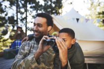 Neugierige Vater und Sohn mit Fernglas auf Campingplatz — Stockfoto