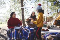 Happy lesbian couple and daughter enjoying breakfast at sunny campsite in woods — Stock Photo