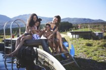 Portrait of happy lesbian couple with kids at remote, sunny, summer poolside — Stock Photo