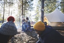 Coppia lesbica e bambini si rilassano nel campeggio soleggiato nel bosco — Foto stock