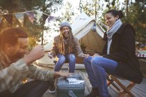Amici felici che giocano a carte al campeggio — Foto stock