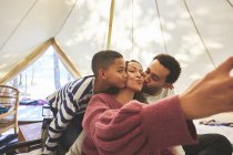 Família feliz e afetuosa tomando selfie no acampamento yurt — Fotografia de Stock