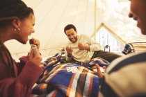 Family playing cards inside camping yurt — Stock Photo