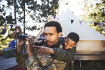 Curious father and son with binoculars at campsite — Stock Photo