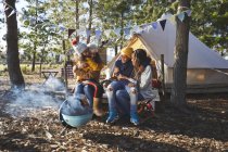 Happy, affectionate lesbian couple with kids at sunny campsite — Stock Photo