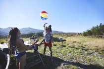 Famiglia allegra e giocosa con beach ball nel soleggiato campo estivo — Foto stock