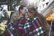 Parents heureux et affectueux embrassant son fils, relaxant au camping — Photo de stock