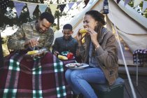 Famiglia che mangia mais sulle pannocchie del campeggio — Foto stock
