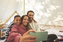 Famille heureuse et affectueuse prenant selfie dans la yourte de camping — Photo de stock