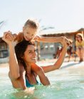 Happy mother and daughter playing in sunny ocean — Stock Photo