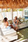 Mother and adult daughter talking and relaxing on beach hut patio — Stock Photo