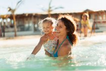 Happy mother and daughter swimming in sunny ocean — Stock Photo