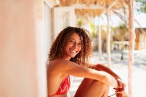 Retrato mujer joven feliz en bikini relajante en el patio soleado cabaña de playa - foto de stock