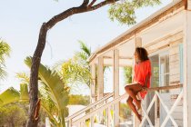 Jeune femme sereine se détendre sur la plage ensoleillée patio hutte — Photo de stock