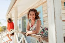 Portrait smiling, confident woman on sunny beach hut patio — Stock Photo
