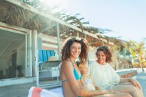 Porträt glückliche Mehrgenerationenfrauen, die es sich vor einer sonnigen Strandhütte gemütlich machen — Stockfoto