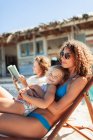 Portrait happy daughter relaxing with mother on sunny beach — Stock Photo