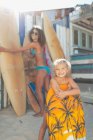 Портрет щасливої матері і дочки з дошкою для серфінгу і бугі на сонячному пляжі — стокове фото