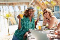 Портрет счастливая женщина пьет коктейль в солнечном пляжном баре — стоковое фото