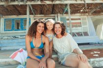 Portrait femmes heureuses multi-générations à l'extérieur de la cabane de plage ensoleillée — Photo de stock