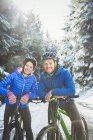 Retrato de pareja de ciclismo de montaña en la nieve - foto de stock