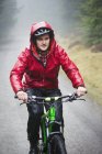 Man mountain biking in rain — Stock Photo
