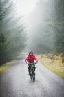 Чоловік катається на гірських велосипедах під дощем — стокове фото