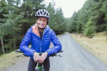 Portrait smiling woman mountain biking — Stock Photo