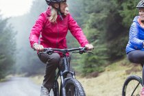 Bicicleta de montaña mujer en bosque - foto de stock