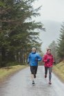 Couple jogging dans les bois — Photo de stock