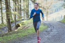 Woman jogging in woods — Stock Photo