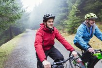 Father and son mountain biking in woods — Stock Photo