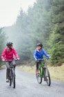 Жінки гірські велосипеди в лісі — стокове фото