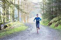 Femme jogging dans les bois — Photo de stock