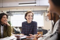 Усміхнені бізнес-леді говорять на зустрічі — стокове фото