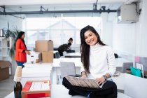 Portrait smiling, confident businesswoman using laptop in new office — Stock Photo