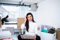 Portrait confident businesswoman using laptop in new office — Stock Photo