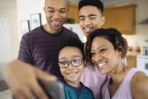 Famiglia sorridente che si fa selfie a casa — Foto stock