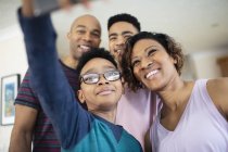 Familia feliz tomando selfie en casa - foto de stock